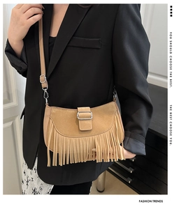 Détail du sac besace en daim marron avec de longues franges et une boucle argentée