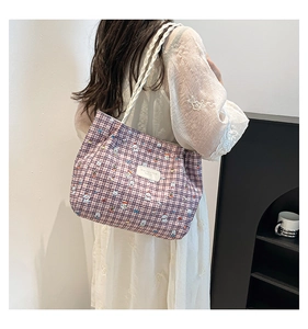 Detail of checkered tote bag with cartoon puppy print and white rope handle texture