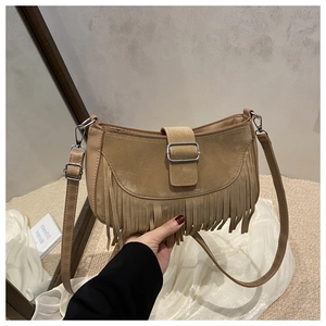 Détail du sac besace en daim camel avec de longues franges et un fermoir à boucle en cuir