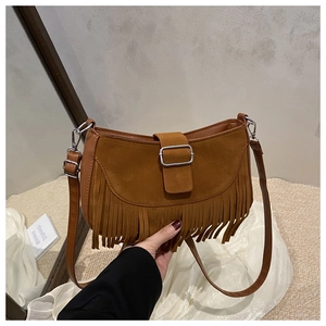 Détail du sac à bandoulière en daim marron avec de longues franges et boucle en métal