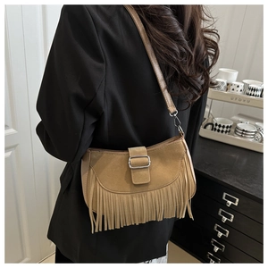 Détail du sac demi-lune en daim marron avec franges denses et boucle argentée