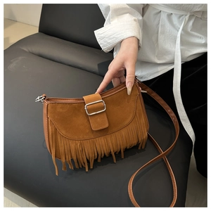 Détail du sac bandoulière bohème marron foncé avec franges et boucle argentée
