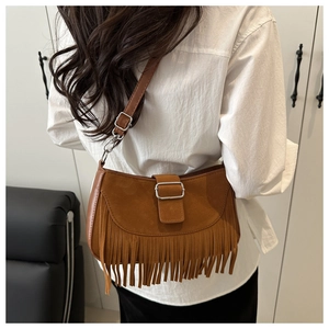 Détail du sac à bandoulière marron en daim à franges avec boucle sur le mannequin