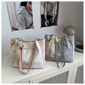 Detail of Korean-style tote bags with lace bows and chain straps in a lifestyle setting