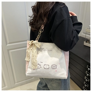 Shoulder shot of pink canvas tote with puppy print, lace bow, and metal chain strap