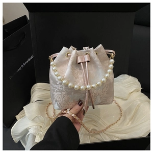 Detail of pink floral jacquard bucket bag with pearl handle and golden chain strap