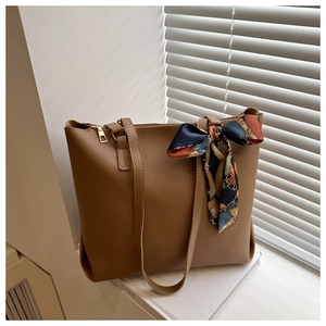 Détail d'un sac cabas en cuir PU marron avec un foulard en soie à fleurs bleu et orange