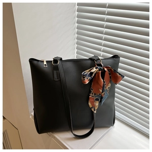 Détail d'un sac cabas noir en similicuir avec un élégant foulard en soie décoratif à motif