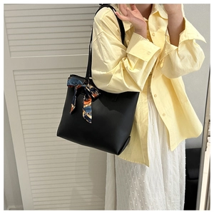 Détail du grand sac cabas noir mat avec foulard en soie à motifs bleu et orange