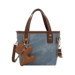 Grand sac cabas en denim avec finitions en cuir marron et breloque petit bonhomme