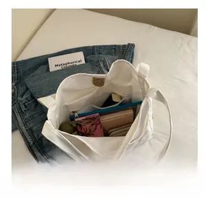 Detail view of large canvas tote bag showing interior compartments and magnetic closure