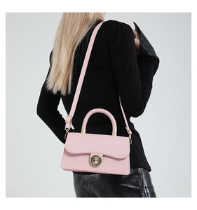 Side view of pink oil wax leather mini bag with golden twist lock on a fashion model
