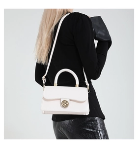 Detail of white rectangle handbag with round gold twist lock and a sleek top handle