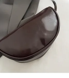 Detailed macro view of dark brown glossy patent leather texture with gold lettering logo
