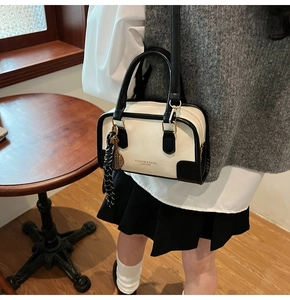 Detail of a black and white bowling bag with tennis racket charm in a vintage cafe