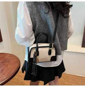 Detail of contrast stitch Boston bag with woven tassel and Fashion text print