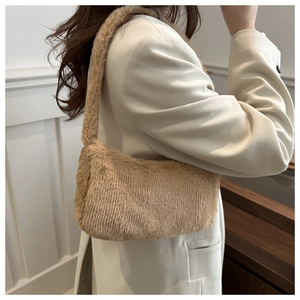 Détail de la texture en fausse fourrure camel sur un sac porté épaule minimaliste