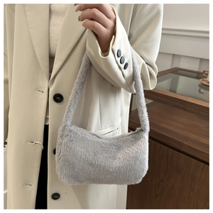 Detail of light gray faux fur underarm bag showing soft texture and premium zipper closure