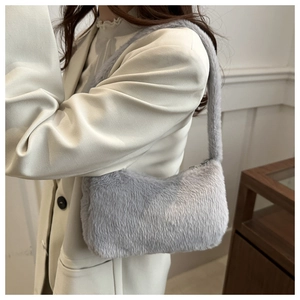 Close-up of light grey plush shoulder bag featuring soft faux fur texture and wide strap
