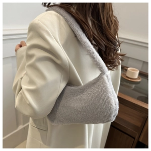Close-up of light grey plush shoulder bag in a stylish minimalist interior setting