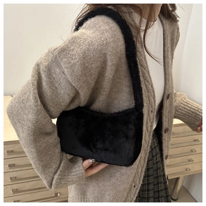Side view of soft black faux fur underarm bag worn with casual autumn outfit