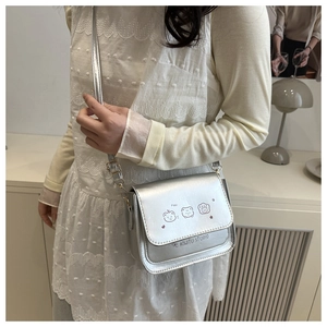 Detail of silver crossbody bag with cute cartoon prints and slim shoulder strap