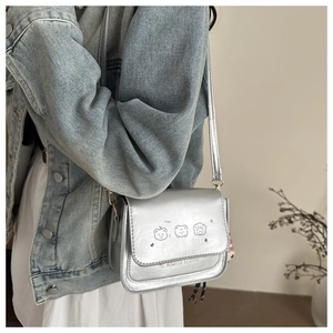 Detail of silver crossbody bag with cute animal prints and KOWITO STUDIO branding