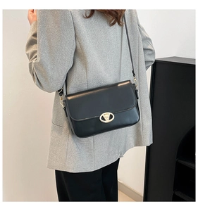 Détail du petit sac à bandoulière noir avec boucle métallique ovale dorée chic