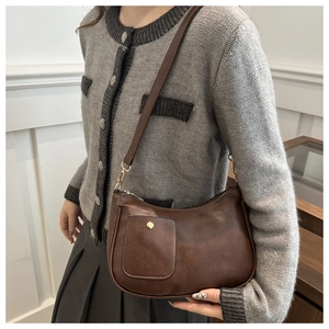Close-up of brown PU leather crescent messenger bag with adjustable shoulder strap