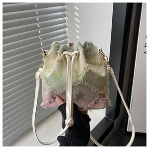 Detail of a vintage drawstring bucket bag with star patterns and frayed canvas texture