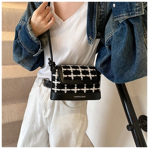 Detail view of small plaid tweed handbag with leather base and knotted shoulder strap