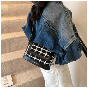 Detail of checkered tweed and black leather shoulder bag with Fashion & Bags text logo