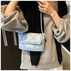 Close-up of light blue quilted crossbody bag with FASHION & BAGS text and slim shoulder strap