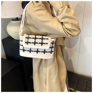 Detail of tweed crossbody bag with star pattern and knotted shoulder strap