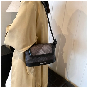 Detail of the plaid shoulder bag featuring black leather trim and side knot strap design