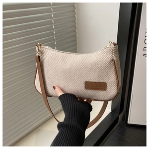 Détail du sac bandoulière en tweed rétro avec finitions en cuir brun et boucles en métal