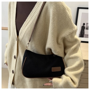 Sac sous le bras en toile noire minimaliste avec bordure en cuir marron sur mannequin