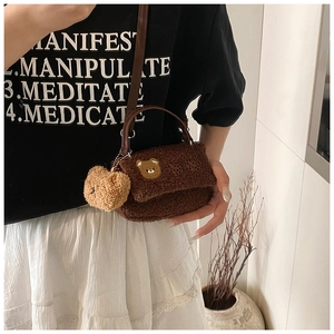 Détail du sac bandoulière en peau lainée marron foncé avec broderie et pendentif ours