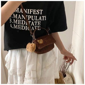 Détail du sac bandoulière en fausse fourrure marron avec broderie d'ours et breloque
