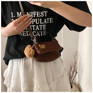 Gros plan détaillé d'un mini sac bandoulière en polaire marron avec patch d'ours