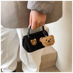Détail du mini sac cabas en peau de mouton noire avec broderie ours et breloque peluche