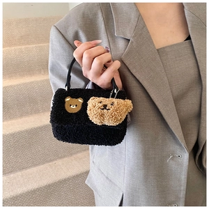 Détail du sac à main en laine d'agneau noire avec broderie d'ours et pendentif ours en peluche