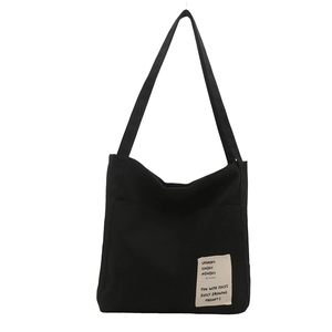 Minimalist black canvas tote bag for women featuring a stylish artistic patch decoration