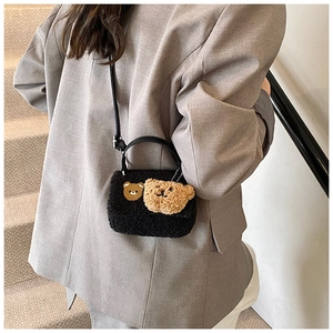 Détail du sac bandoulière en peluche noire avec ours mignon et poignée en cuir élégante