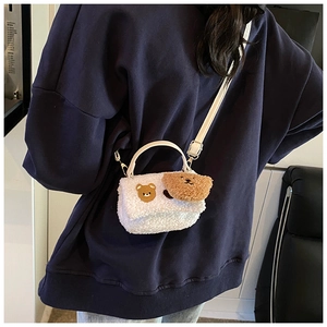 Détail du sac en faux mouton blanc avec broderie ours brun et charm en peluche assorti