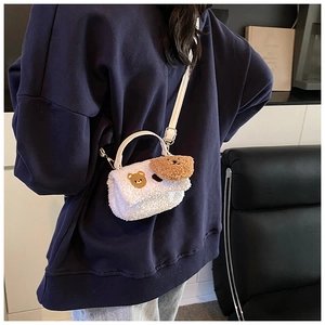 Détail de la bandoulière en peau de mouton blanche avec broderie d'ours mignon