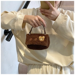 Vue détaillée de la texture douce en laine d'agneau marron et broderie d'ours sur le sac