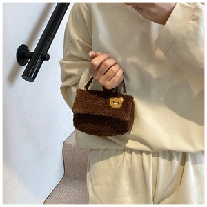 Gros plan d'un sac à main en laine d'agneau marron avec broderie d'ours en peluche