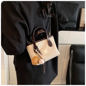 Detailed back view of a cream and brown contrast tote bag with baseball themed charms