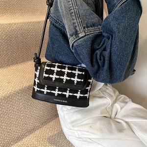 Chic black and white plaid crossbody bag with leather trim for spring 2025 fashion